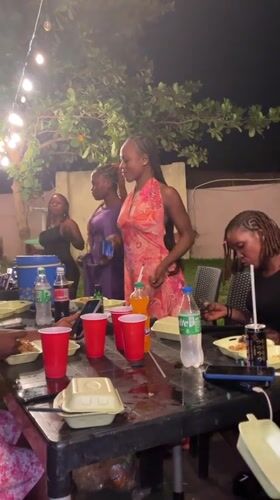 Young women celebrate at nighttime outdoor party in Nigeria