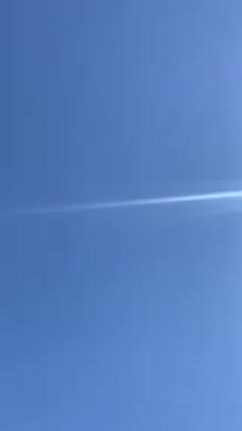 Here is a description of the video:

The video is a close-up shot of a bright blue sky with a bright, shining sun. The sun creates a lens flare effect in the video, making it appear as a thin, white line across the frame. There are no other objects or people visible in the video.