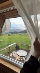 Curtains opened to reveal mountain valley view from Montenegro patio