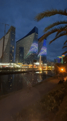 Evening lights illuminate modern Batumi cityscape and recreation areas