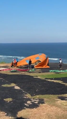 Paragliding operations documented on Indonesian clifftop morning session