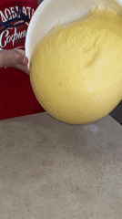 Baker pours yellow dough in Bulgarian kitchen