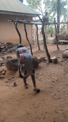 Woman sweeps yard in early morning, Akwanga Nigeria
