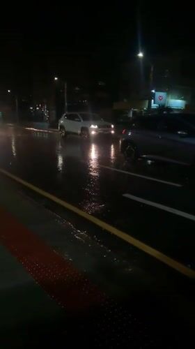 Vehicles navigate wet streets during night in Curitiba