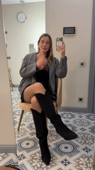 Woman takes mirror selfie in Moscow wearing blazer outfit