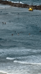 Surfers, sailboats, and aircraft over the Netanya coast