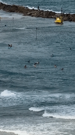 Surfers, sailboats, and aircraft over the Netanya coast