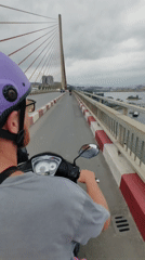 Scooter rider crosses modern bridge in Hong Gai Ward