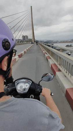 Scooter rider crosses modern bridge in Hong Gai Ward