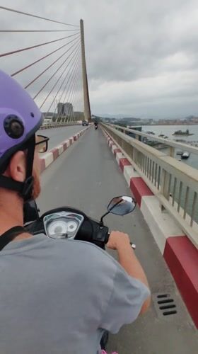Scooter rider crosses modern bridge in Hong Gai Ward