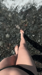 Person in black bikini enters turbulent ocean waters