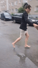 Barefoot through puddles, shoes in hand after the rain