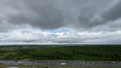 Highway traffic flows normally near Kudrovo under cloudy skies