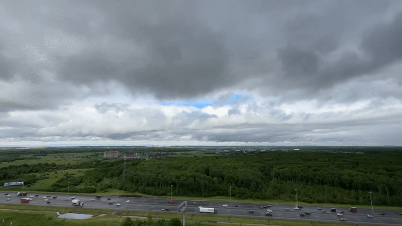 Highway traffic flows normally near Kudrovo under cloudy skies