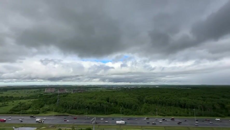 Highway traffic flows normally near Kudrovo under cloudy skies