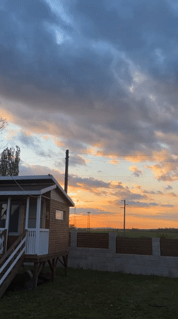 Dramatic sunset documented over wooden cabin in Pchelnik, Bulgaria