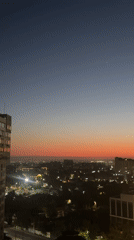 City skyline glows at dusk in blue-to-orange gradient