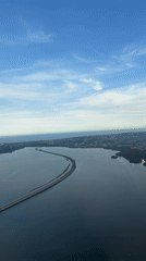 Aerial view captures curving bridge over water in Kuta