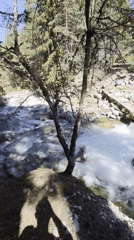 Clear river flows over rocks beneath concrete bridge