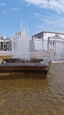 Morning pedestrians gather around fountain in Yekaterinburg square