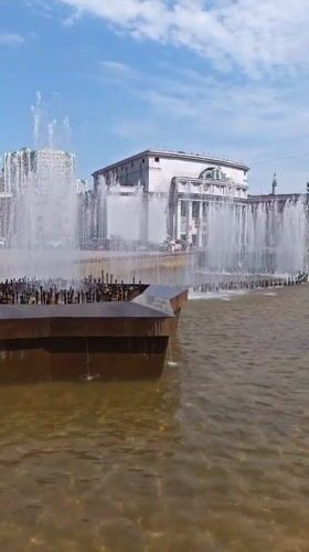 Morning pedestrians gather around fountain in Yekaterinburg square