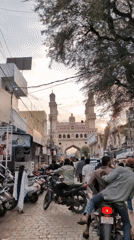 Evening street life near Charminar features floating heart balloons