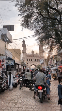 Evening street life near Charminar features floating heart balloons
