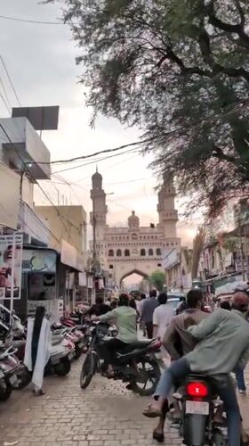 Evening street life near Charminar features floating heart balloons