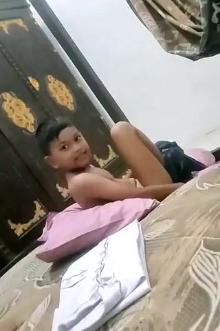 A child is lying on a bed, then gets up and crawls toward the camera.