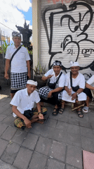 Five men in traditional dress gather on North Kuta sidewalk