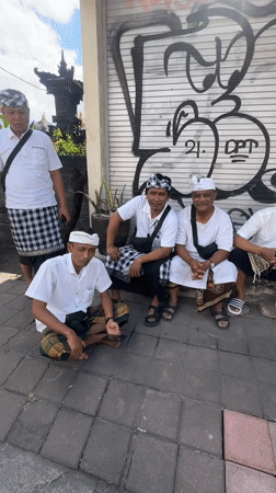 Five men in traditional dress gather on North Kuta sidewalk