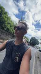 Tourist takes selfies while riding scooter in Kuta Selatan