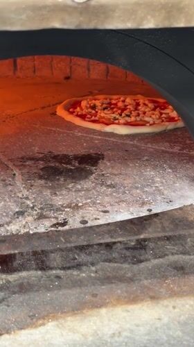 Full kitchen in motion: pizza, espresso, and prep work in Palmanova