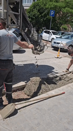 Construction crew repairs sidewalk with concrete mixer truck