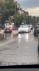 Flooded streets in Kryvyi Rih as cars navigate heavy rain