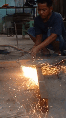 Torch cutting metal on a dusty Simpang Pematang street