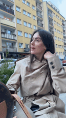 Woman takes playful selfies at outdoor Warsaw cafe
