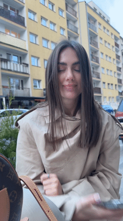 Woman takes playful selfies at outdoor Warsaw cafe