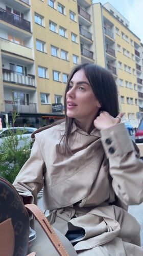 Woman takes playful selfies at outdoor Warsaw cafe