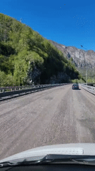 Vehicle crosses textured bridge in mountainous Monastyr, Russia
