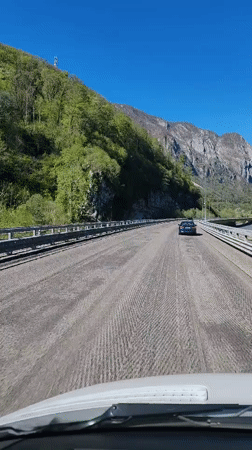 Vehicle crosses textured bridge in mountainous Monastyr, Russia