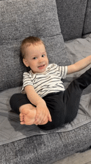 Toddler plays happily on couch in Rusanovo home