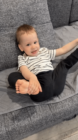 Toddler plays happily on couch in Rusanovo home