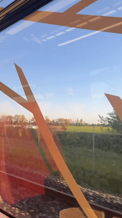 Train passenger records countryside view near Pusignan, France
