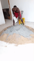 Man mixes cement and sand for construction project indoors