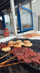 Spiced meat skewers on a charcoal grill in Ado, Nigeria