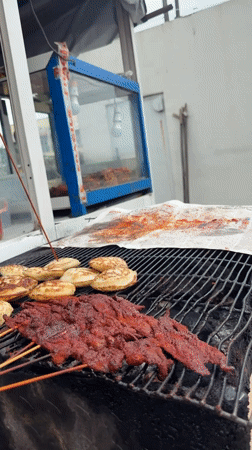 Spiced meat skewers on a charcoal grill in Ado, Nigeria