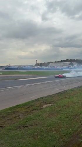 Red sports car practices drifting on Ostrovtsy race track