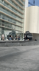 Skateboarder performs tricks in Barcelona plaza during sunny afternoon