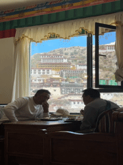 Two men dine with Potala Palace view in Lhasa